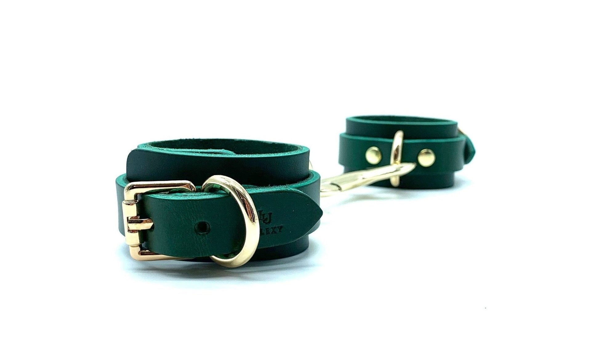 Pair of green leather handcuffs with greensuede, displayed side by side, highlighting their shiny silver buckles, designed for both aesthetic appeal and functional bondage use, crafted with precision in the USA.