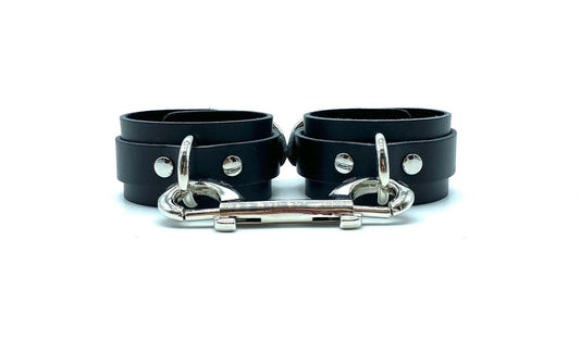 Front view of high-quality black Italian suede handcuff featuring a sturdy nickel-plated D-ring and connector, crafted in the USA, perfect for BDSM bondage enthusiasts seeking durable and stylish restraints.