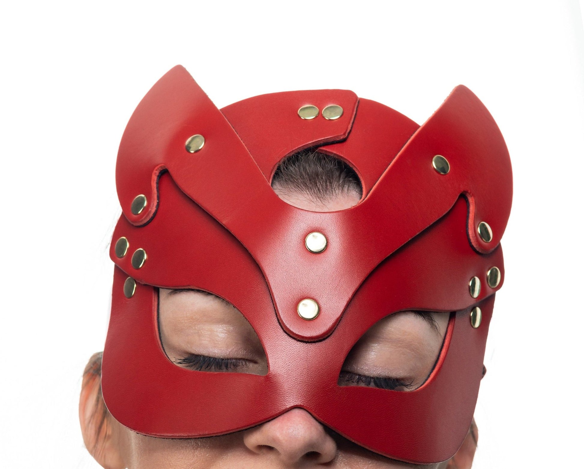 Lulexy red cat mask, constructed from fine Italian leather and lined with matching red suede. The mask showcases top-quality hardware and a cat-like silhouette with prominent ears and large eye openings, ideal for a striking masquerade look.