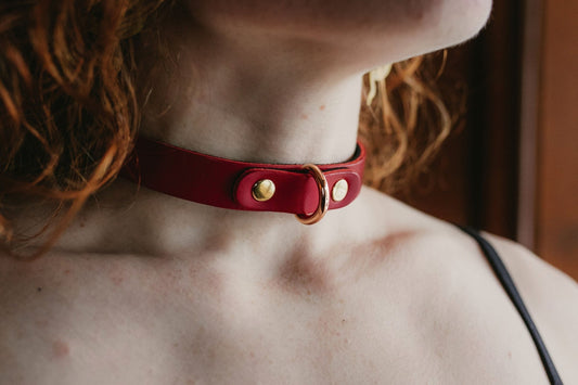Model wearing red Buttero Italian leather choker with gold hardware, elegant minimalist collar design