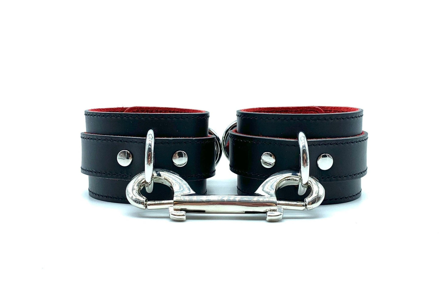 Italian BDSM bondage cuffs in Scarlet design, displaying the captivating combination of black leather and red suede cuffs positioned side by side, accentuated by the gleaming silver hardware, designed for both aesthetic appeal and functional performance.