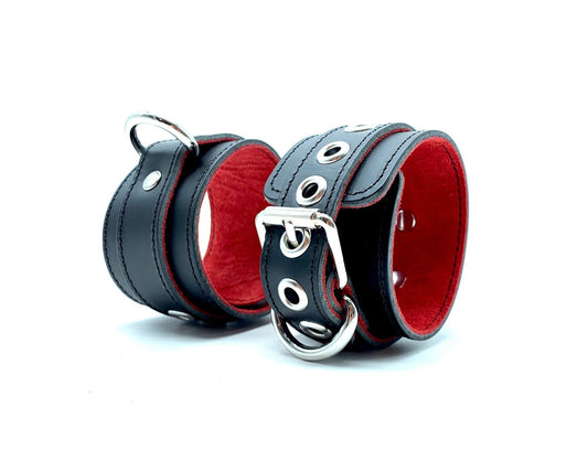 Italian BDSM bondage cuffs in Scarlet design, crafted with black leather and vibrant red suede, positioned side by side to showcase the sleek silver hardware, offering both style and security for intimate bondage play.