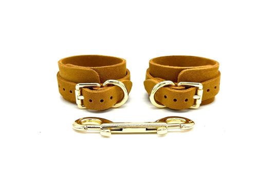 Italian suede BDSM bondage cuffs made in the USA, featuring vibrant yellow suede cuffs positioned side by side, adorned with luxurious gold hardware and matching connectors, designed for both style and security in intimate bondage play.