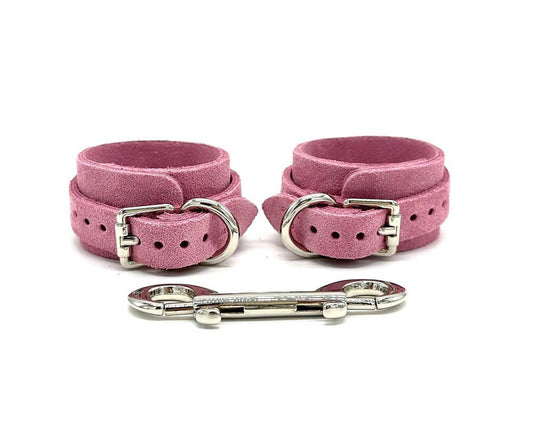 Italian suede BDSM bondage cuffs made in the USA, showcasing sleek and luxurious cuffs positioned side by side, featuring elegant silver hardware and a matching connector, designed to provide both style and security for discerning bondage enthusiasts.