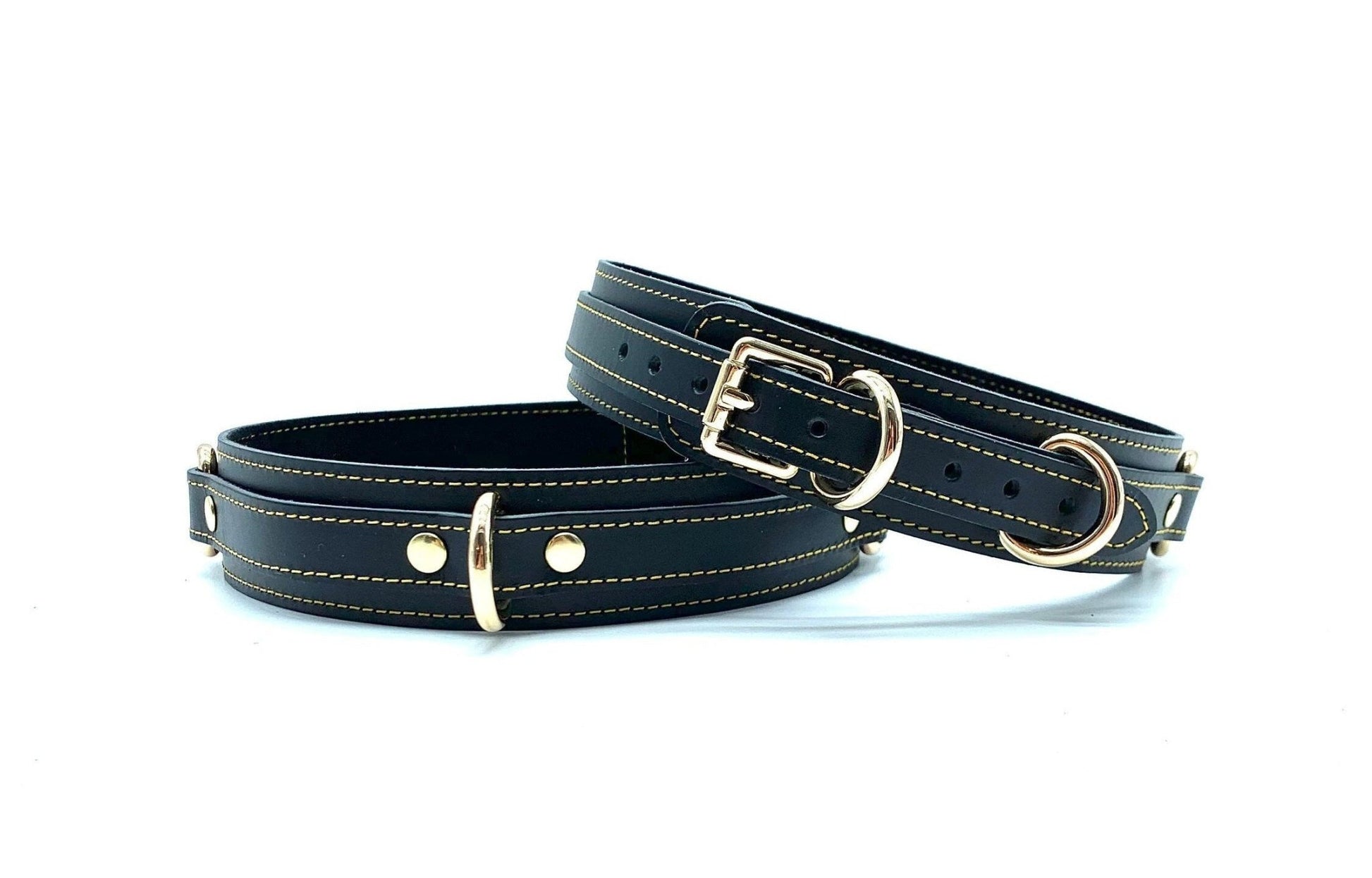 Front view of Tango Black Italian leather BDSM bondage thigh cuffs, showcasing the sleek black leather with detailed gold stitching and polished gold hardware, crafted in the USA.