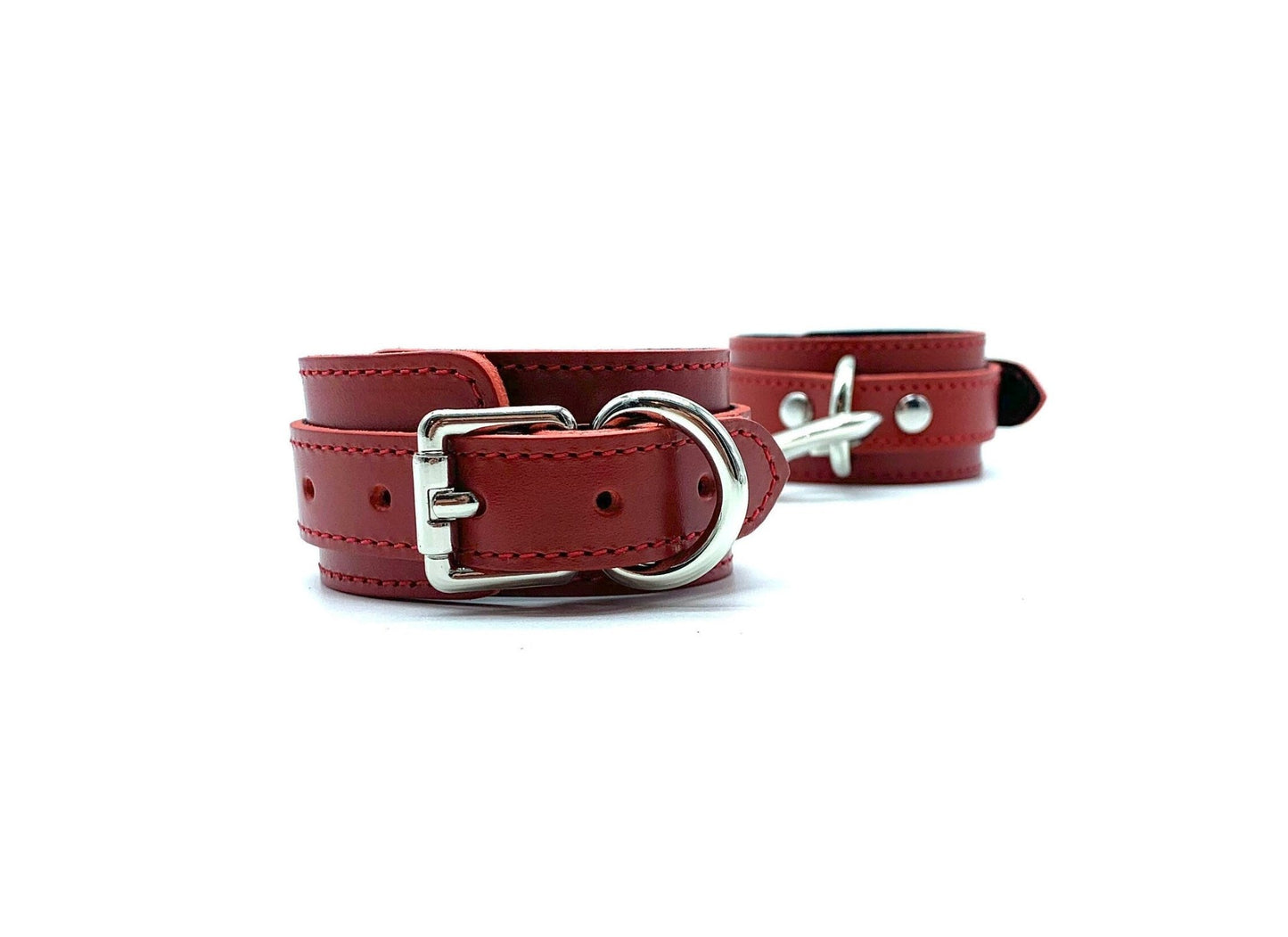 Pair of BDSM bondage cuffs made of Italian leather and suede, crafted in the USA, connected side by side, highlighting their durable silver buckles, demonstrating a perfect blend of luxury, comfort, and security.