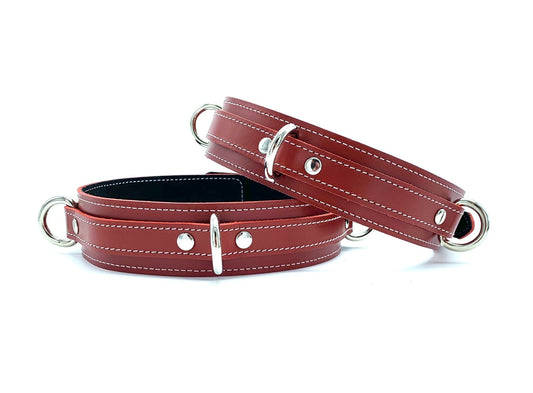 Front View with Buckles: Vibrant Tango Red Italian leather thigh cuffs displayed from the front, with shining silver buckles and loops clearly visible, set against a clean white background.