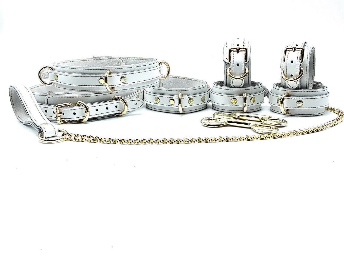 Complete set of seven Italian white leather and suede BDSM bondage pieces made in the USA, showcasing a soft white leather and sumptuous white suede adorned with striking gold hardware and exquisite gold stitching, providing a comprehensive collection of premium-quality restraints for sophisticated bondage play.