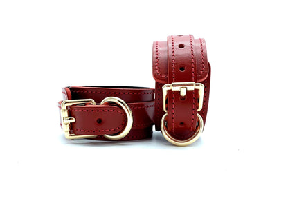 red leather cuffs in the Tango Red BDSM Kit, connected on the side with gold hardware, enhancing the BDSM experience with superior bondage features and meticulous craftsmanship."