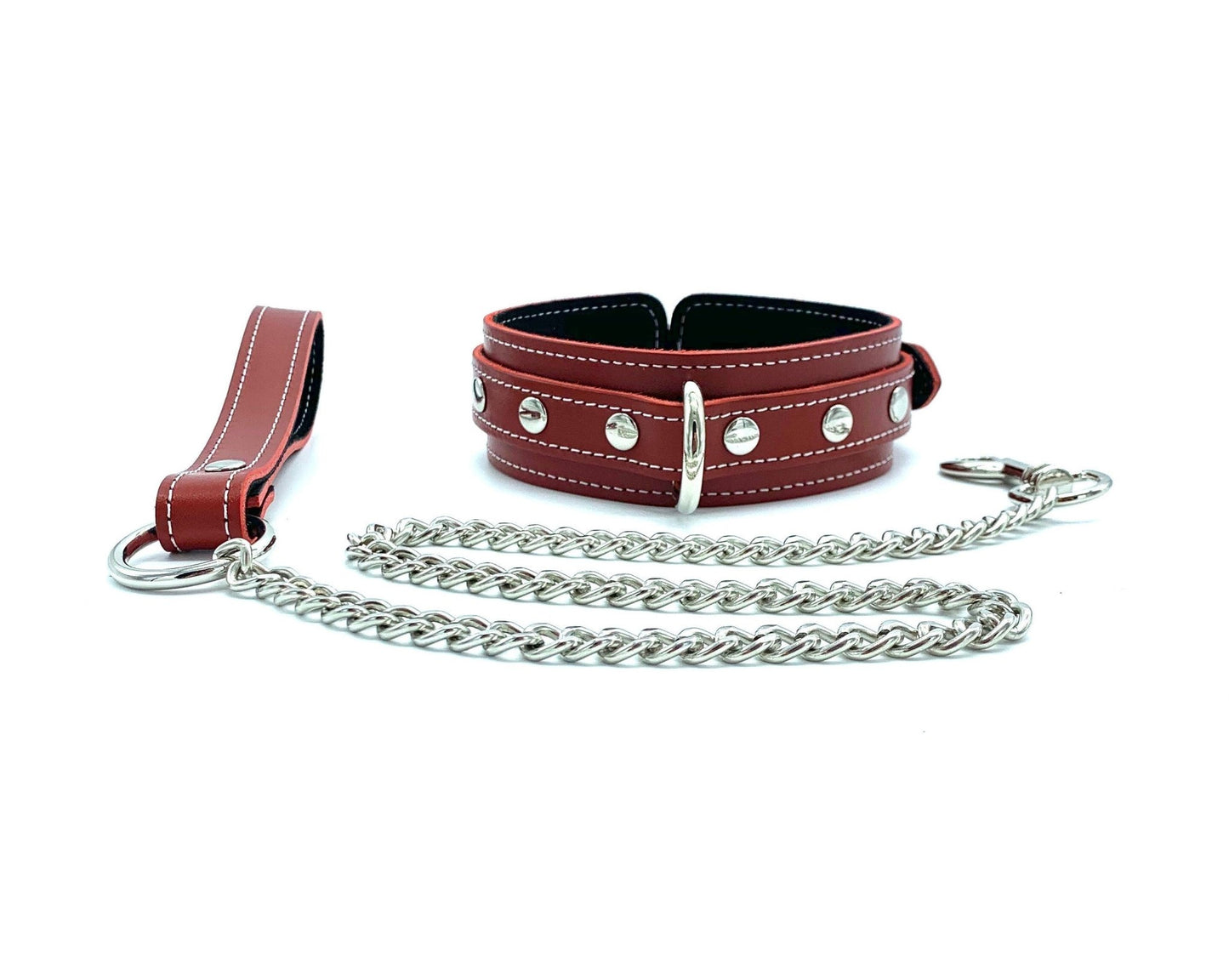 Red leather collar with a leash featuring a silver chain from the Tango Red BDSM Kit. The collar and leash are detailed with black suede and white stitching, emphasizing luxury and precision in BDSM gear.