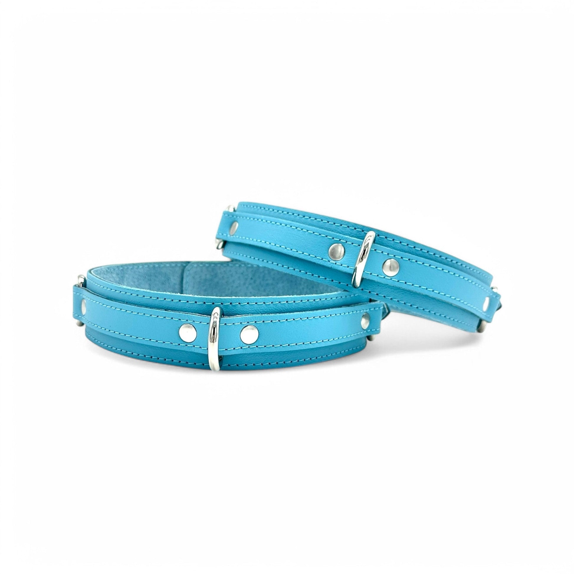 Light blue leather thigh cuffs with detailed stitching and silver D-rings for attachment points.