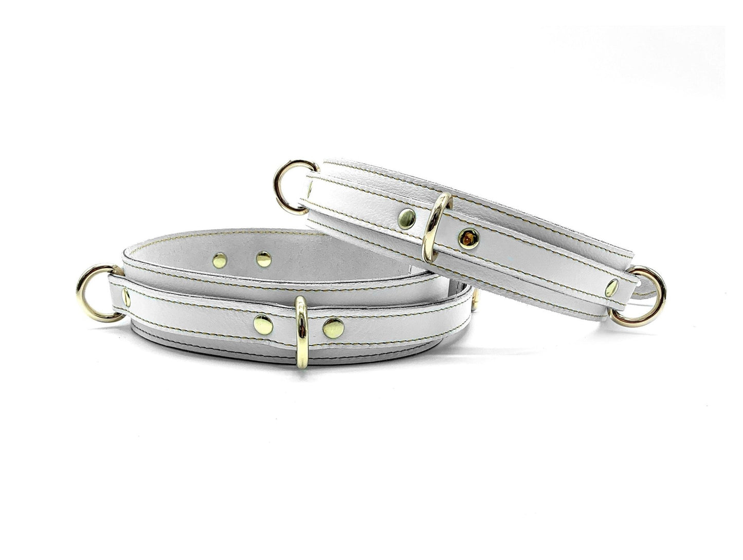 White Italian leather thigh cuffs with gold hardware, adjustable wrist cuffs with buckle closure
