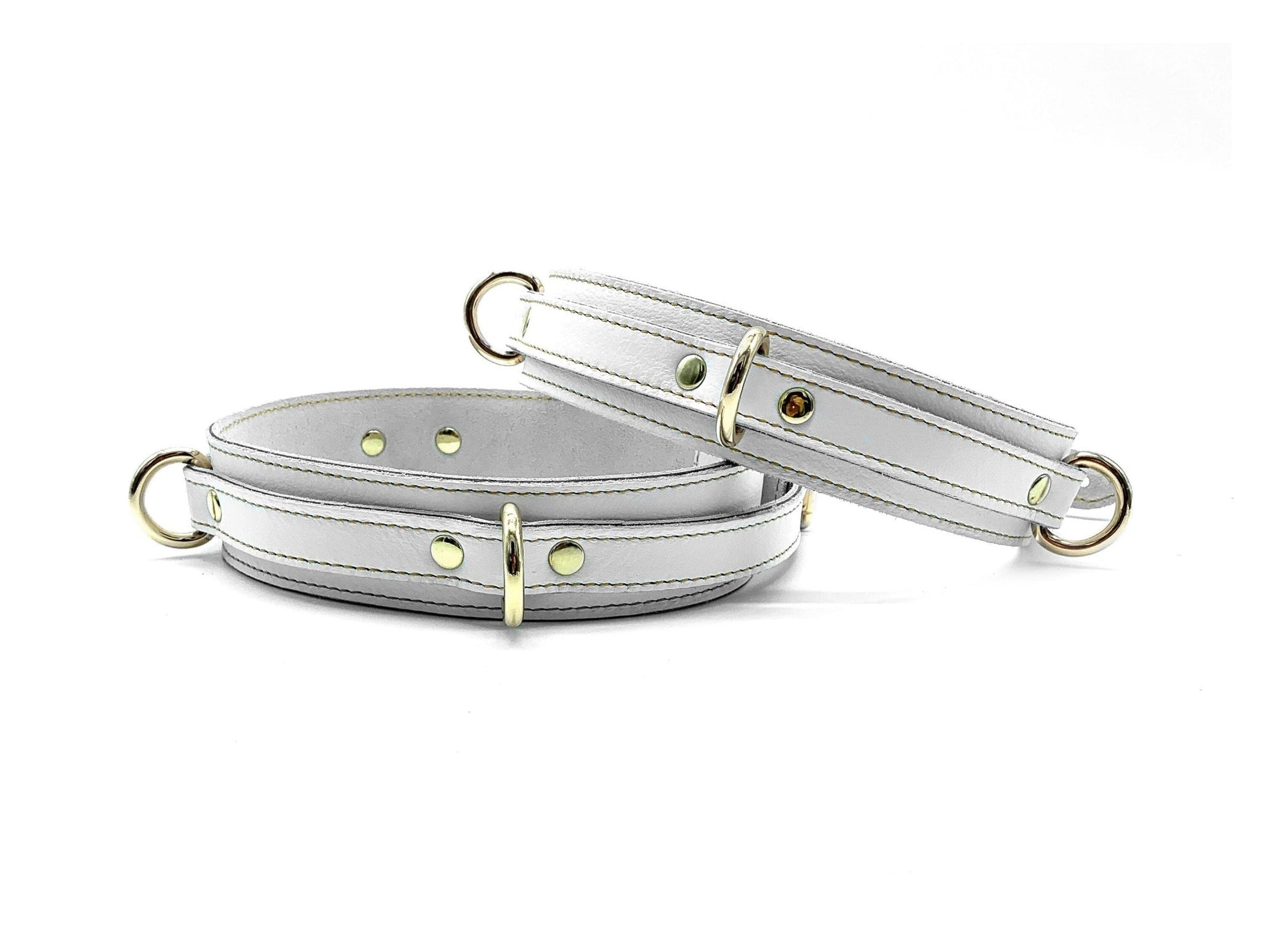 White Italian leather thigh cuffs with gold hardware, adjustable wrist cuffs with buckle closure