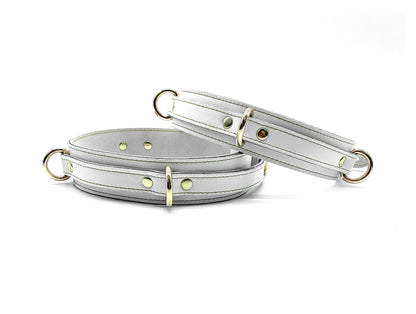 White Italian leather thigh cuffs with gold hardware, adjustable wrist cuffs with buckle closure