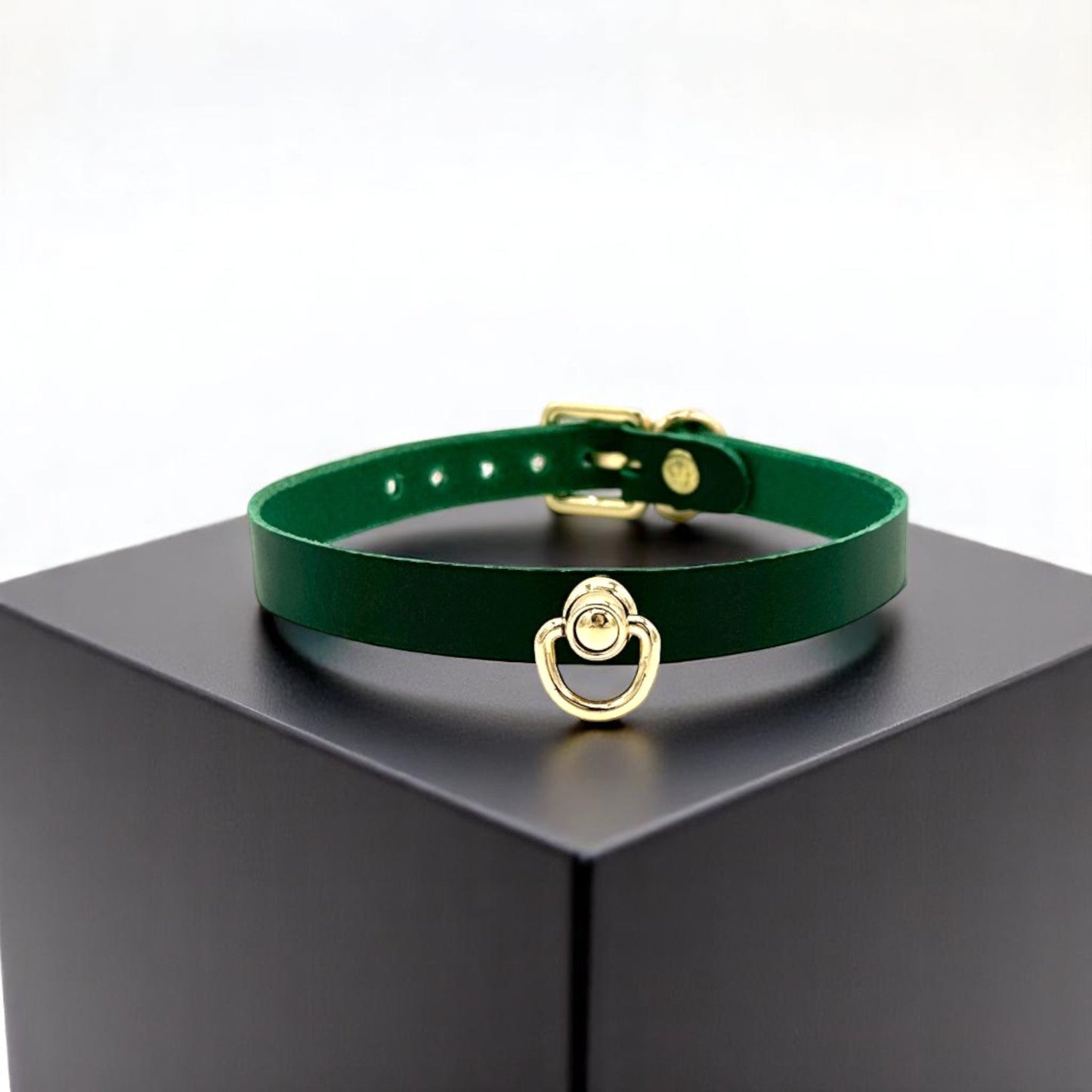 Green Buttero Italian leather choker with gold hardware and center D-ring, minimalist collar on display