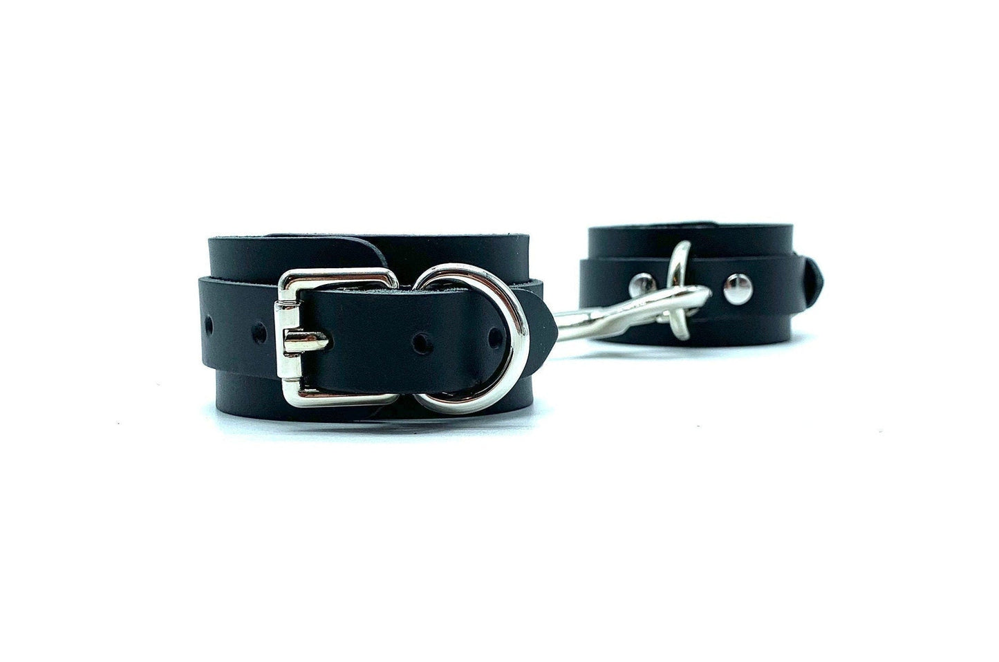 Pair of connected Italian leather handcuffs with high-quality nickel-plated hardware, showcasing the durability and elegant design of BDSM accessories made in the USA, ideal for secure and versatile bondage play.