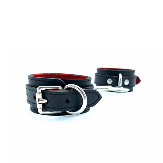 Black leather cuffs with red lining and silver hardware, adjustable wrist cuffs with buckle closure