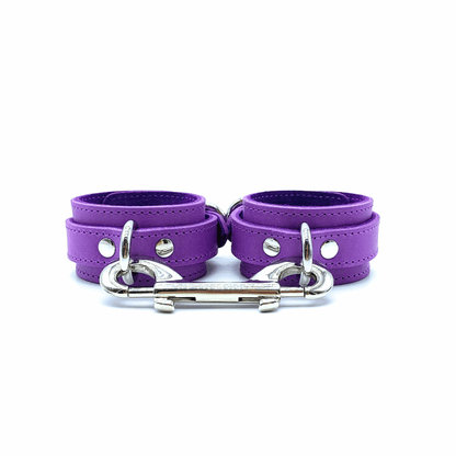 Purple leather handcuffs with silver hardware, paired adjustable cuffs with clean finish