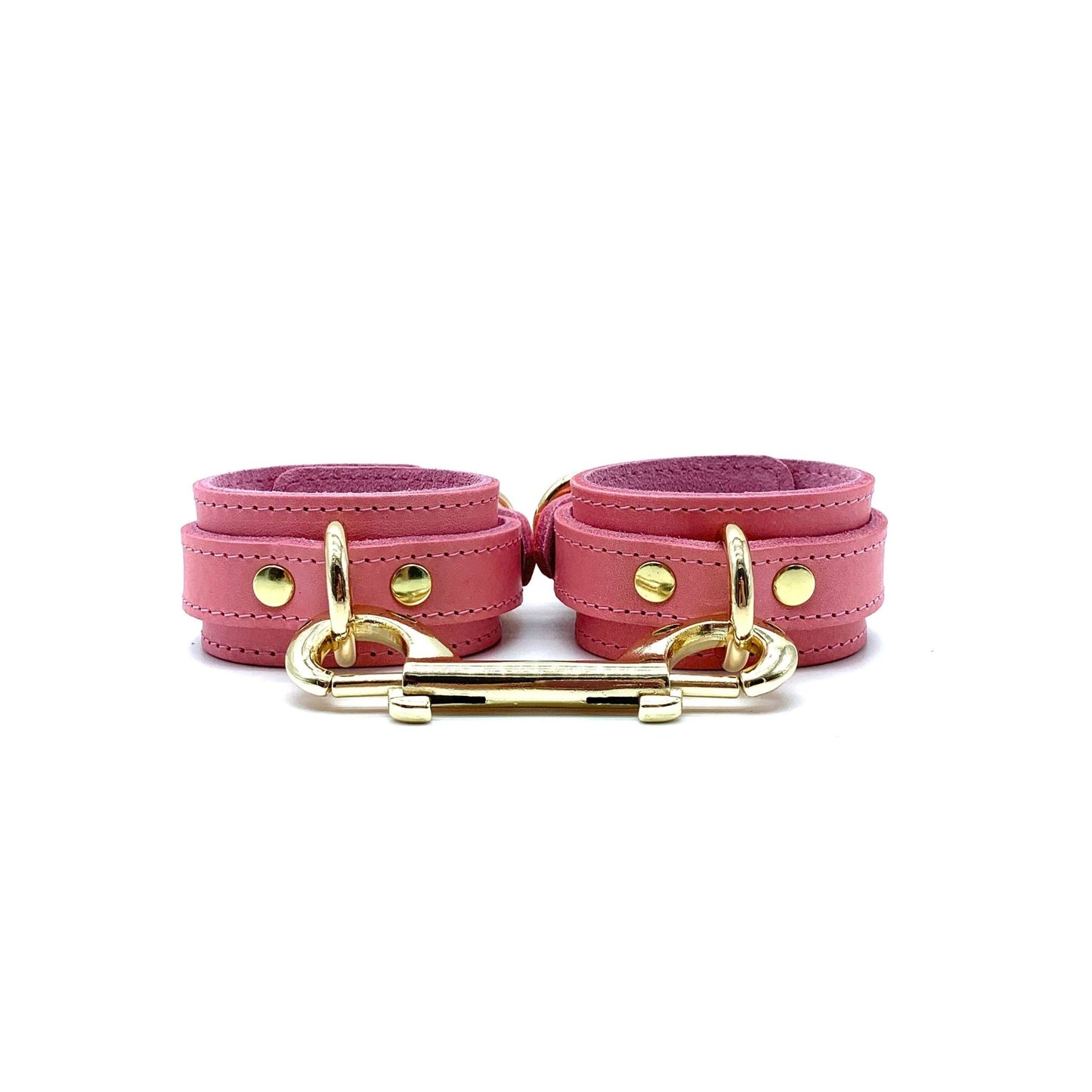 Pink leather handcuffs with gold hardware, adjustable wrist cuffs with buckle closure