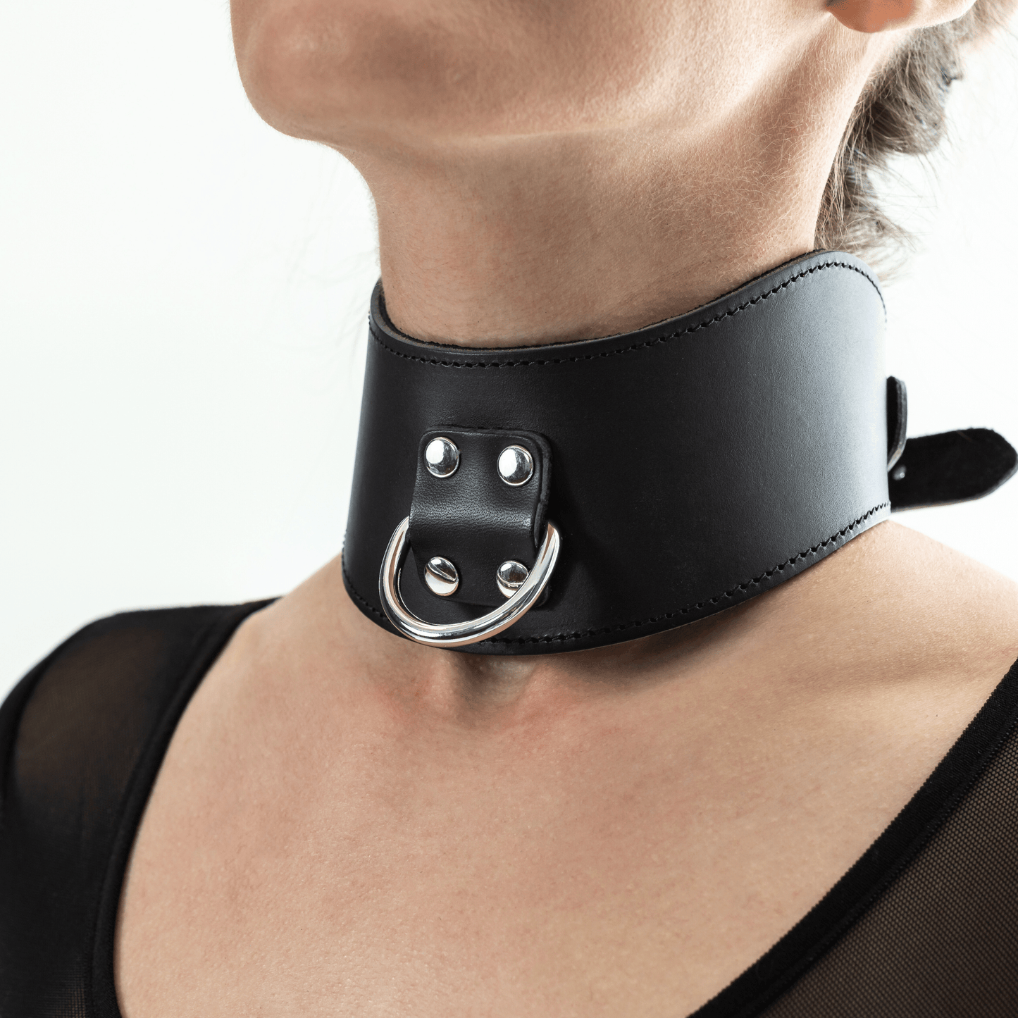 Black leather posture collar with silver hardware on a model in lifestyle setting