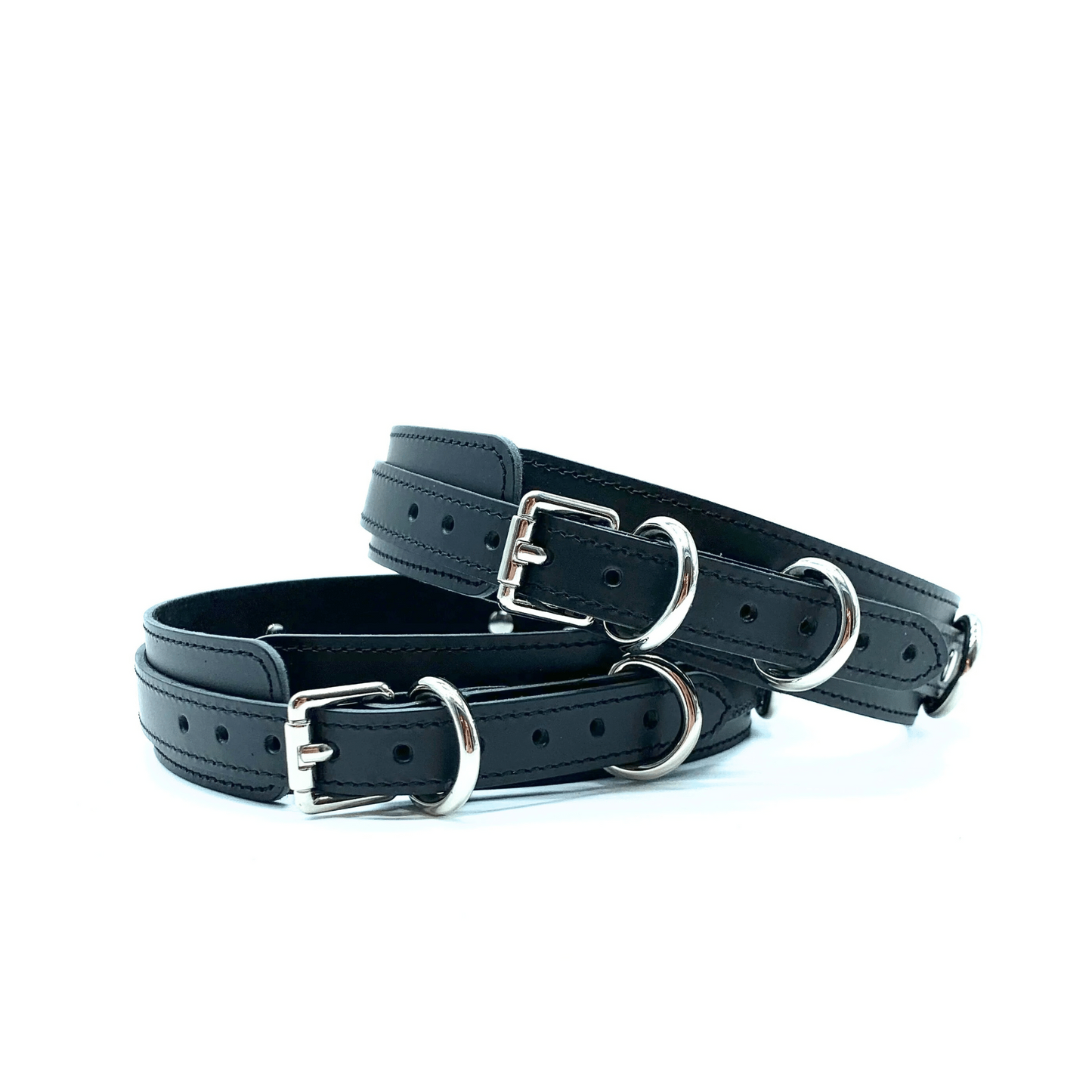 Black leather thigh cuffs featuring elegant silver buckles and multiple adjustment holes. 