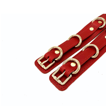 Close up of red Buttero Italian leather thigh cuffs with gold buckles, adjustable straps and rivet detail