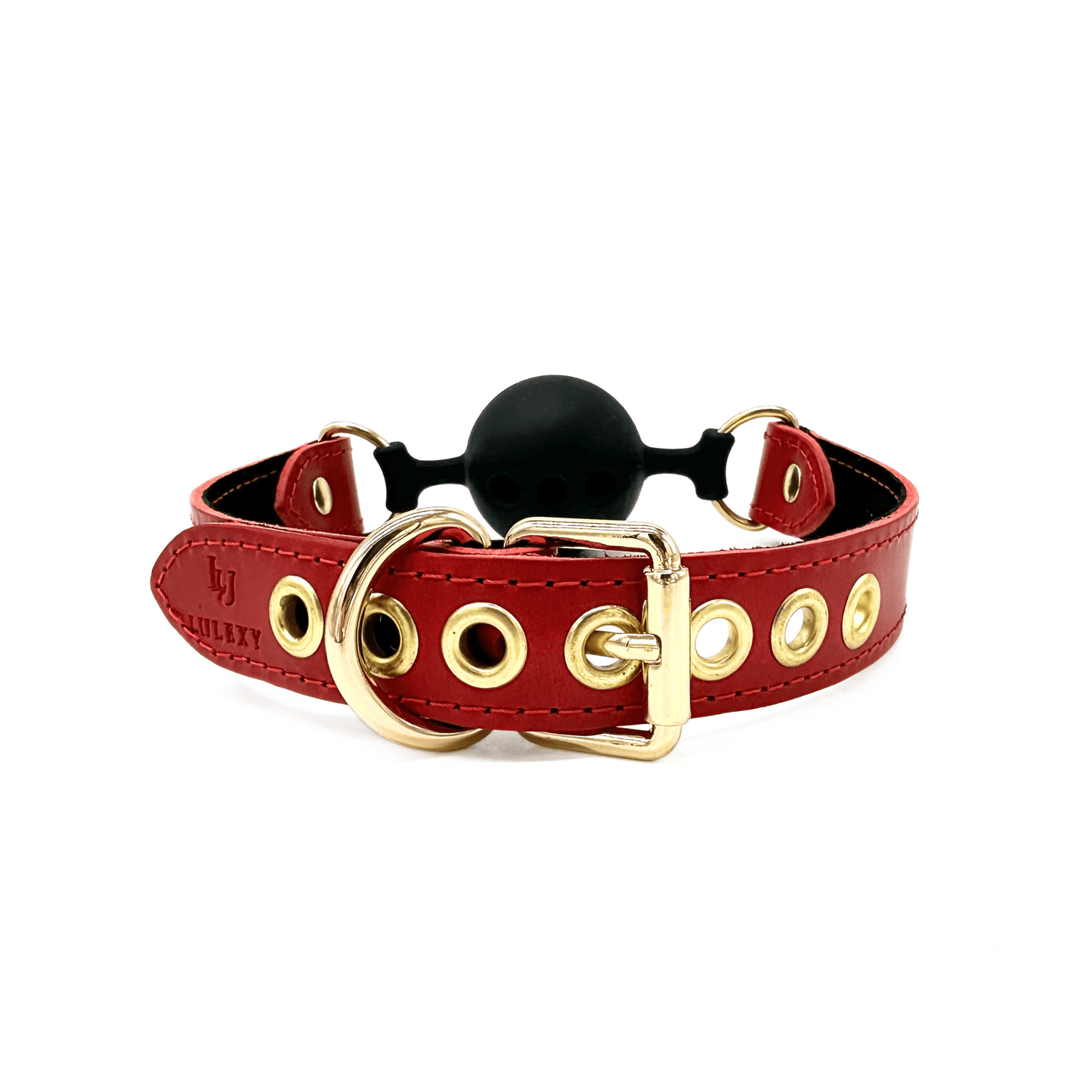 Close-up of gold buckle on red leather ball gag strap with metal eyelets for size adjustment