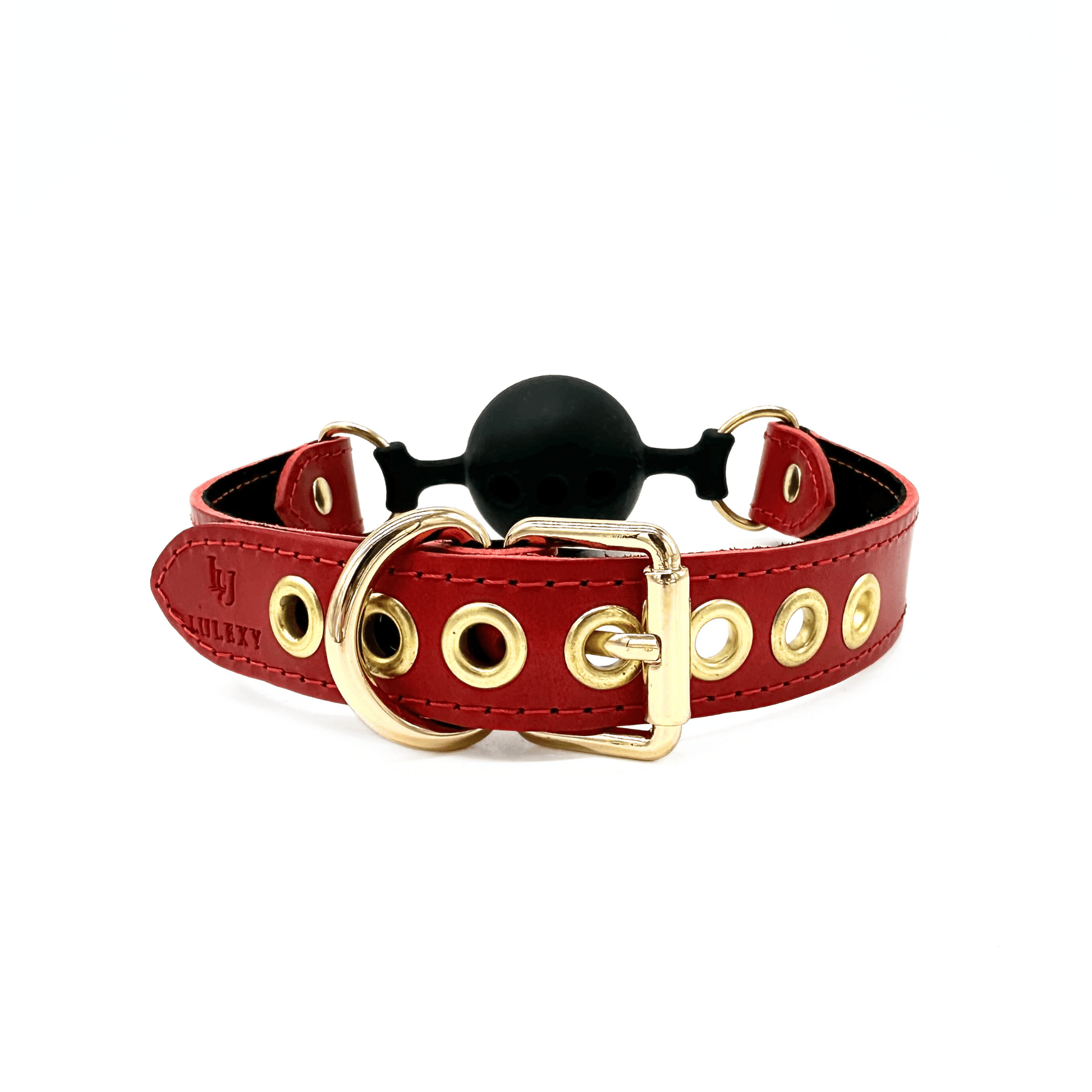 Close-up of gold buckle on red leather ball gag strap with metal eyelets for size adjustment