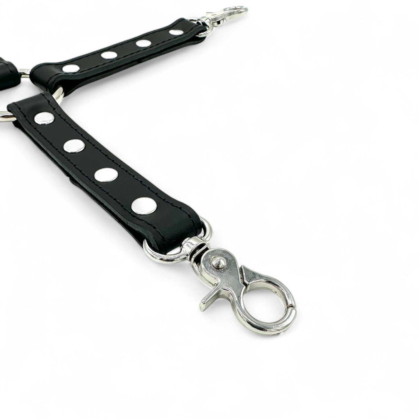 close up of black leather hogtie connector strap with detailed stitching, silver snap hook and rivet details.
