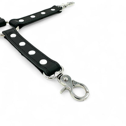 close up of black leather hogtie connector strap with detailed stitching, silver snap hook and rivet details.