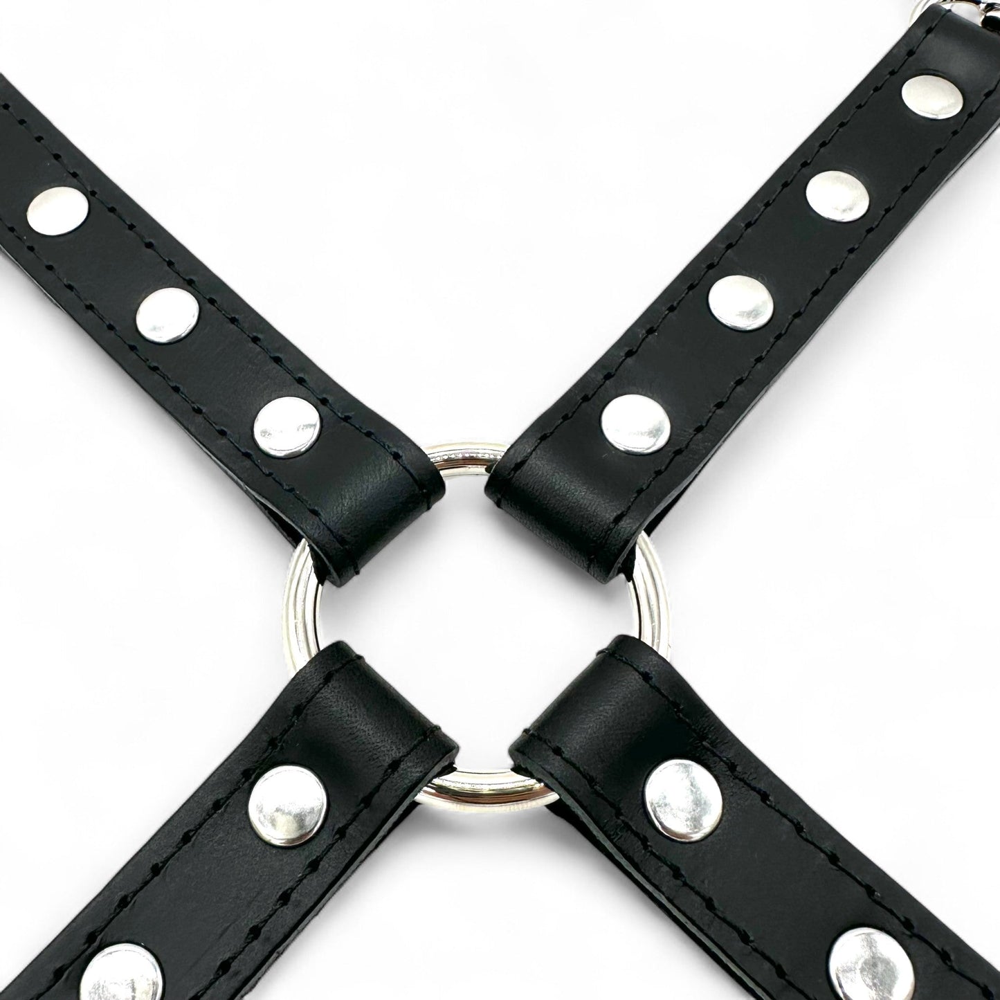 Close up image of black leather hogtie connector with stitched outline, silver rivets and central O-ring.
