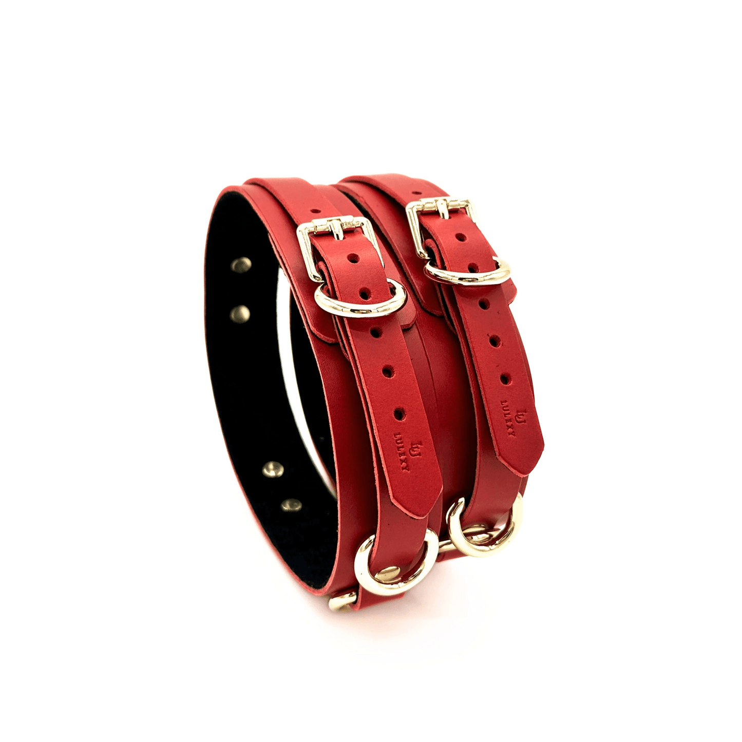 Red leather thigh cuffs upright with gold hardware, adjustable straps and embossed Lulexy logo on white