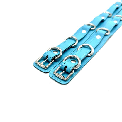 Blue Italian leather thigh cuffs close up with silver buckles and hardware, adjustable strap design